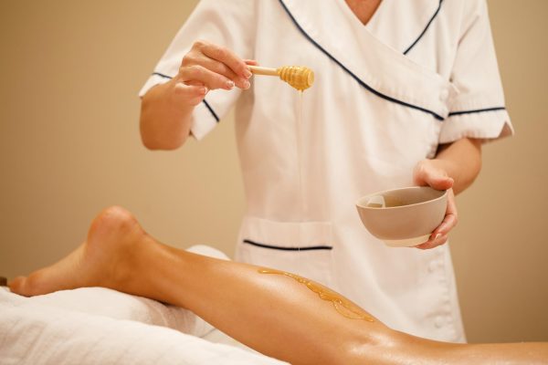 unrecognizable-therapist-pouring-honey-while-massaging-woman-s-leg-spa-salon (1)